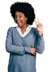 Wall Mural - Young african american woman wearing business clothes smiling with happy face winking at the camera doing victory sign. number two.