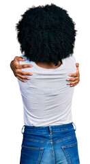 Wall Mural - Young african american woman wearing casual white t shirt hugging oneself happy and positive from backwards. self love and self care