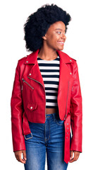 Sticker - Young african american woman wearing red leather jacket looking away to side with smile on face, natural expression. laughing confident.