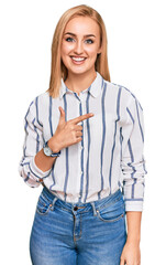 Wall Mural - Beautiful caucasian woman wearing casual clothes cheerful with a smile on face pointing with hand and finger up to the side with happy and natural expression