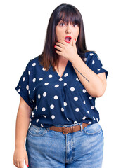 Canvas Print - Young plus size woman wearing casual clothes looking fascinated with disbelief, surprise and amazed expression with hands on chin