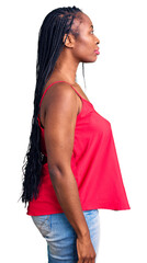 Poster - Young african american woman wearing casual clothes looking to side, relax profile pose with natural face with confident smile.