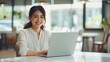 © Serhii - Business woman working on a laptop in a bright, open workspace. A young student or remote teacher is working in online education, remote work.
