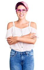 Wall Mural - Young beautiful woman with pink hair wearing casual clothes and glasses happy face smiling with crossed arms looking at the camera. positive person.