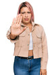 © Krakenimages.com - Hispanic woman with pink hair wearing casual clothes doing stop sing with palm of the hand. warning expression with negative and serious gesture on the face.