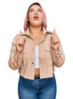 © Krakenimages.com - Hispanic woman with pink hair wearing casual clothes amazed and surprised looking up and pointing with fingers and raised arms.