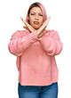 © Krakenimages.com - Hispanic woman with pink hair wearing casual winter sweater rejection expression crossing arms doing negative sign, angry face