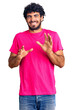 © Krakenimages.com - Handsome young man with curly hair and bear wearing casual pink tshirt disgusted expression, displeased and fearful doing disgust face because aversion reaction. with hands raised
