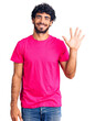 © Krakenimages.com - Handsome young man with curly hair and bear wearing casual pink tshirt showing and pointing up with fingers number five while smiling confident and happy.