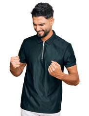 Wall Mural - Young man with beard wearing sportswear excited for success with arms raised and eyes closed celebrating victory smiling. winner concept.