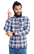 © Krakenimages.com - Young arab man wearing casual clothes with a big smile on face, pointing with hand and finger to the side looking at the camera.
