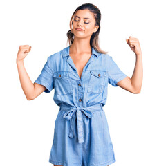 Poster - Young beautiful woman wearing casual clothes showing arms muscles smiling proud. fitness concept.