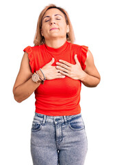 Sticker - Young blonde woman wearing casual clothes smiling with hands on chest with closed eyes and grateful gesture on face. health concept.