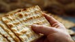 A hand holding a piece of matzah raised high during the recitation of the Four Questions,Traditional of Holiday on Passover.