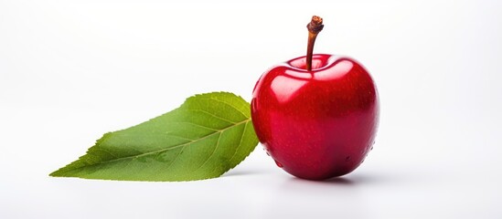 Poster - Fresh red apple with a green leaf placed on a clean white surface, showcasing natural simplicity