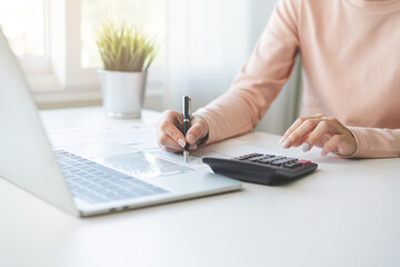 Wall Mural - Deduction planning, debt asian young woman  hand using laptop computer, calculator calculating money balance from bill and income, cost budget expenses for pay money form personal individual on table.