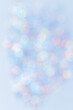 Defocused abstract blue bokeh background pastel colored, flare from lights, color gradient, blurred round bokeh as holiday texture. Glittering aesthetic textured lighting vertical pattern