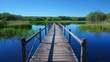 A serene setting as the wooden footbridge stretches over the glasslike surface of the pond perfectly reflecting the clear blue sky . .
