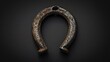 A horseshoe shaped object on a black surface. Suitable for luck and superstition concepts
