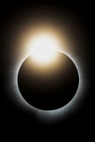 Fototapeta  - The last light from the sun peaks out before it is completely covered by the moon during the total solar eclipse on April 4, 2024. This look is called the diamond ring effect.