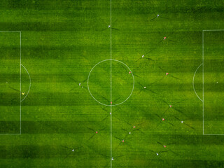 Aerial view of a soccer field in action, with players running, passing, and scoring goals.