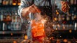 © itchaznong - A bartender is pouring a drink into a glass with a blue flame