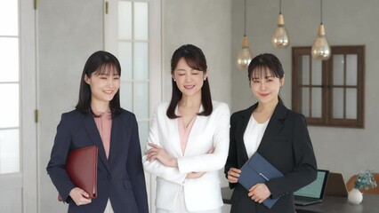 Leinwandbilder - 笑顔でオフィスに並ぶ三人のビジネスウーマン