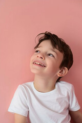 Portrait of a smiling boy on a pink background
