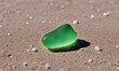 piece of green sea glass on the sand