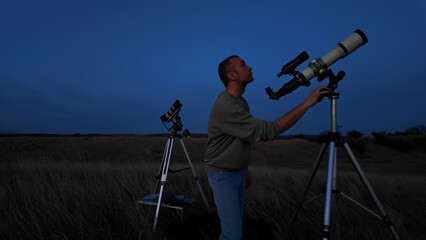 Wall Mural - amateur astronomer looking at the evening skies, observing planets, stars, moon and other celestial 