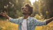 Portrait of a free happy black afro american man with open arms enjoying life in meadows and nature background , young joyful African male with good mental health