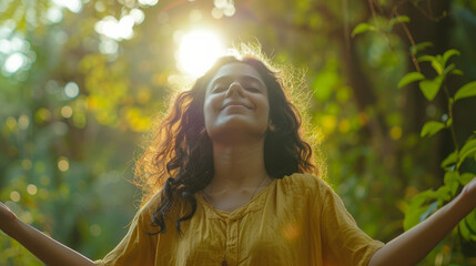 portrait of a free happy indian woman with open arms enjoying life in meadows and nature background 