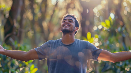 Portrait of a free happy latin american man with open arms enjoying life in meadows and nature background , young joyful latino male with good mental health