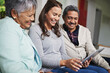 © peopleimages.com - Senior parents, woman and tablet with smile in living room for connection or bonding with tech. Family, home and mature people with young, female person and happy for together on couch in community