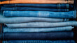 Stack of various shades of blue denim jeans, textile background.	