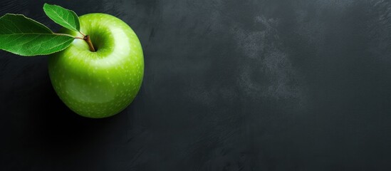 Fototapete - Green apple with leaf on dark backdrop