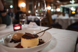 Fototapeta  - Elegant dessert presentation on white plate with flan, cocoa, chocolate garnish, ice cream, berries in luxury hotel dining room in Zermatt, Switzerland.