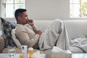 Wall Mural - Sick, man and cough with medication for flu, sinus or illness on living room sofa at home. Tired male person lying on lounge couch with fever, influenza or throat infection from bacteria at the house