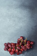 Vibrant Red Grape Bunch on Textured Grey Surface with Space for Text