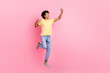 Full body portrait of handsome excited guy jumping hold smart phone make selfie isolated on pink color background
