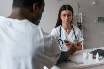 Female doctor measures blood pressure of a man