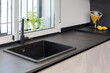 © ADDICTIVE STOCK - Modern kitchen with black sink and window view