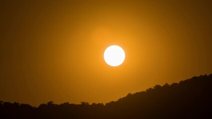 Wall Mural - Timelapse of dramatic sunset with orange sky in a sunny day.