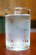 Closeup of a glass of cold water isolated on wooden table