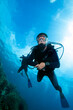 Scuba diver with sun beams rays and sun shine underwater.
