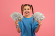 © Prostock-studio - Girl holding money with excited expression on pink background