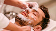 A relaxing moment at the spa portrayed with a man receiving a facial treatment, his face covered in foam, evoking a sense of calm and personal care. Banner. Copy space