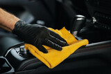 Fototapeta Mapy - car interior cleaning. closeup of hand with microfiber cloth on center console