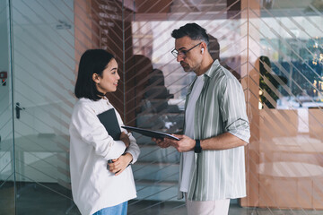 Fototapete - Diverse entrepreneurs talking about business marketing during working process for cooperation, smart casual executive managers with laptop and paperwork communicate during job experience
