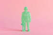 Green plastic soldier toy figure, Isolated on neutral pink background
